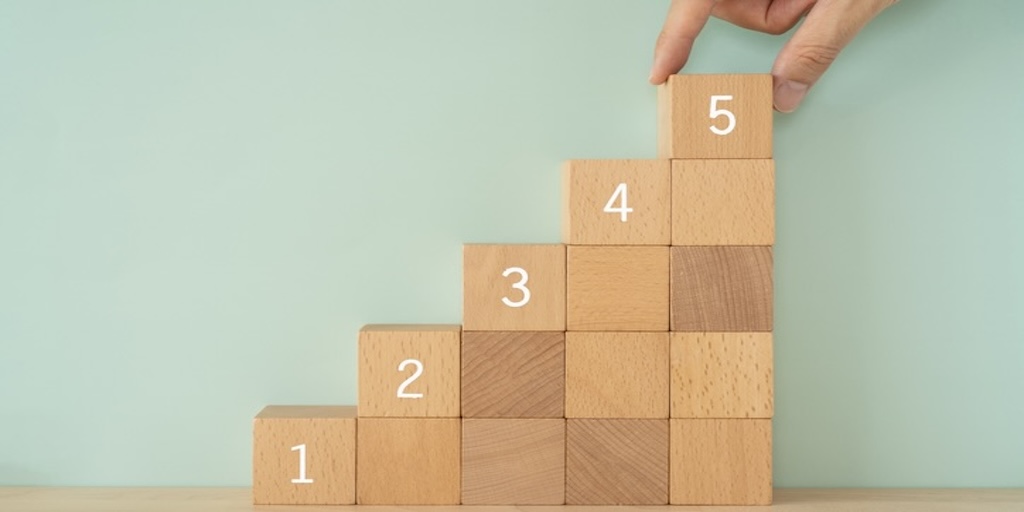 Maximising Value from Your Data - Wooden blocks with numbers and a hand